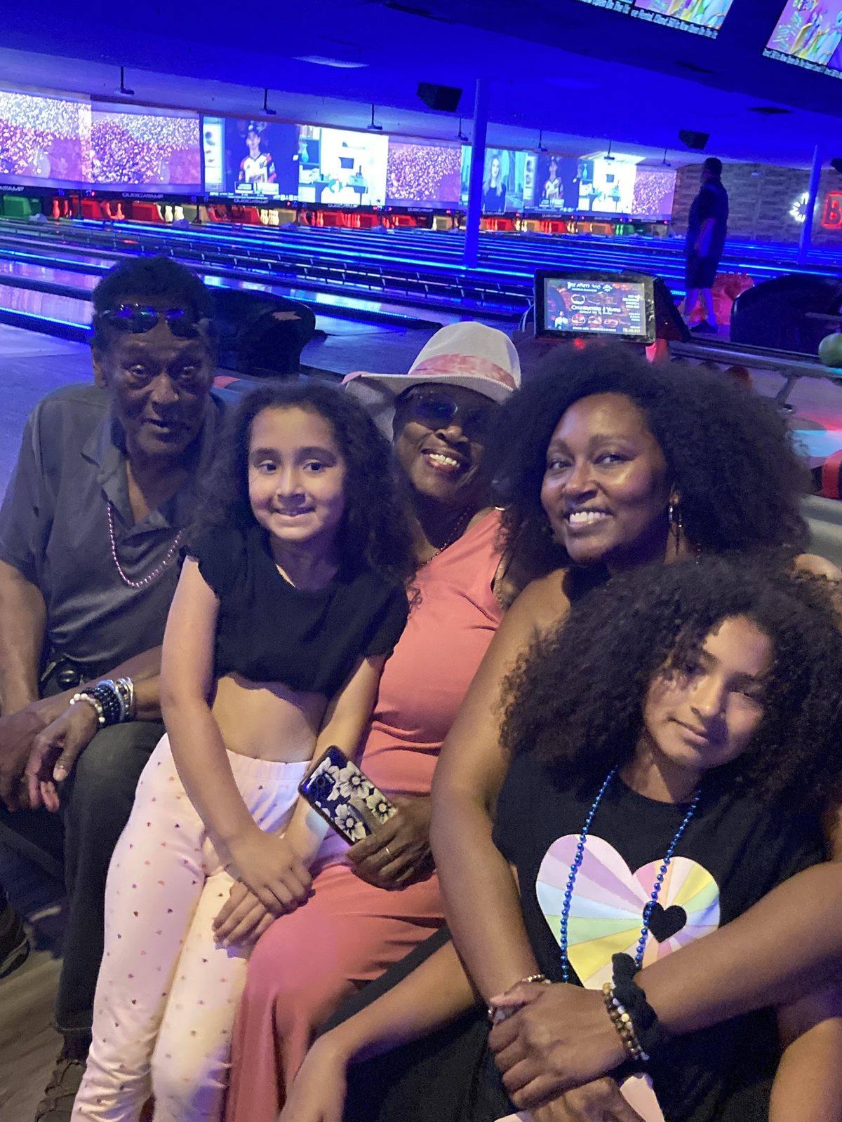 Adults and young people seated together at the bowling lanes