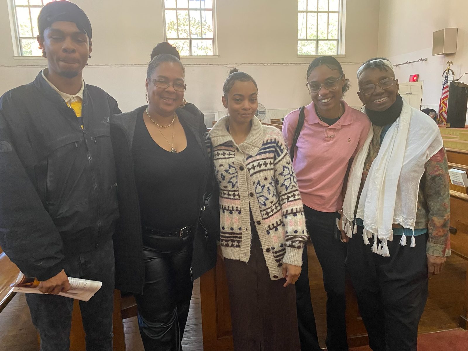 Five members and friends standing together in the sanctuary