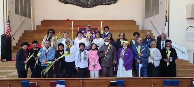 Members of Siloam Presbyterian Church holding palm fronds in the sanctuary