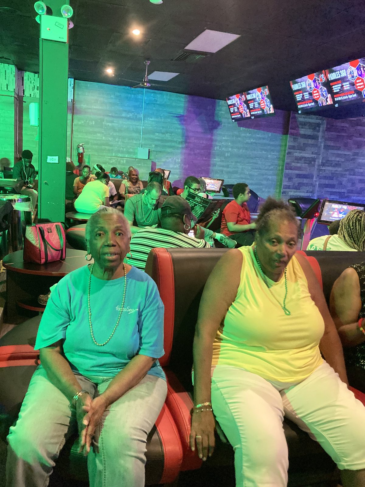 Two women seated side by side at the bowling alley