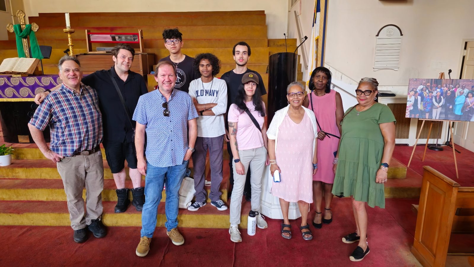 Members and friends standing together in front of the chancel